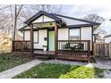 Charming home featuring an inviting covered porch with stylish seating and a vibrant green door at 1529 Harlan St, Indianapolis, IN 46203