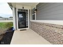 Inviting front entrance with a stylish black door, brick accents, and a small porch, plus installed security system at 17345 Northam Dr, Westfield, IN 46074