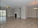 Spacious living room with hardwood floors, a ceiling fan, a cozy fireplace, and sliding glass doors for natural light at 17345 Northam Dr, Westfield, IN 46074
