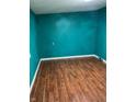 Bedroom featuring dark wood-look floors and freshly painted blue walls with white trim at 4524 E 10Th St, Indianapolis, IN 46201
