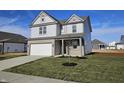 Stylish two-story home featuring gray siding, brick accents, attached garage, and newly planted front yard at 6196 Granby Dr, Whitestown, IN 46075