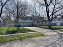 Two-story home with a large driveway, garage, and landscaped front yard at 927 Stockton St, Indianapolis, IN 46260