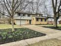 Traditional two story home with an attached two car garage and a well landscaped yard with mulch and flowering bulbs at 927 Stockton St, Indianapolis, IN 46260