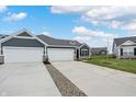 Two-car garage with gray siding and stone accents at 155 Maxim Ct # 093-B, Cumberland, IN 46229
