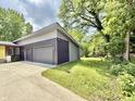 Two-car garage exterior with a modern design and natural surroundings at 7650 Clarion Dr, Indianapolis, IN 46236