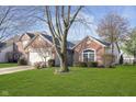 Charming brick single-story home with attached two-car garage, beautiful lawn, and mature tree at 10656 Adam Ct, Fishers, IN 46037