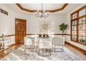 Dining room with a glass table, stylish chairs, and modern chandelier lighting at 1462 Eagle Trace Ct, Greenwood, IN 46143