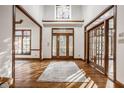 Grand foyer with hardwood floors, ornate wood trim, and a statement chandelier at 1462 Eagle Trace Ct, Greenwood, IN 46143
