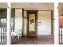 Inviting front porch with white columns and a decorative wooden front door at 545 Fletcher Ave, Indianapolis, IN 46203