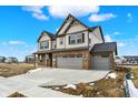 Beautiful two-story home with a brick and vinyl exterior and a spacious three-car garage on a sunny day at 20326 N Pacific Ave, Westfield, IN 46074
