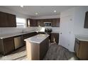 Modern kitchen with dark brown cabinets, stainless steel appliances, and an island at 3912 Highcrest Rd, Indianapolis, IN 46239