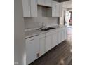 Galley kitchen featuring modern appliances, white cabinets and countertops at 424 N Kealing Ave, Indianapolis, IN 46201