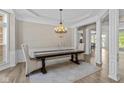Elegant dining room with wainscoting, columns, tray ceiling, and chandelier over a wood table with seating at 10346 Strongbow Rd, Fishers, IN 46040