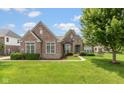 Charming brick home featuring a well-manicured lawn and professionally landscaped flowerbeds at 10346 Strongbow Rd, Fishers, IN 46040