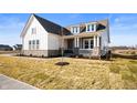 Lovely two-story home with a stone base, white siding, and well manicured lawn at 19566 Wood Farm Pl, Westfield, IN 46074