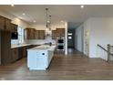 Open-concept kitchen featuring wooden floors, a large island, and stainless steel appliances at 19566 Wood Farm Pl, Westfield, IN 46074