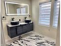 Elegant bathroom with double vanity, marble flooring, and a frameless shower at 3271 Winthrop Ave, Indianapolis, IN 46205