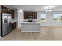 Modern kitchen with island, stainless steel appliances, and hardwood floors at 3950 Bozeman Way, Bargersville, IN 46106