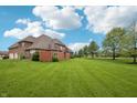 Expansive backyard featuring lush green grass and mature trees, perfect for outdoor activities at 1038 White Oak Dr, Plainfield, IN 46168