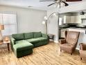 Inviting living room with a comfortable green sofa and hardwood floors, blending relaxation with timeless appeal at 2104 N Ball Ave, Muncie, IN 47304
