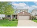 Charming two-story home with a brick facade, attached two-car garage, and well-maintained landscaping at 14446 Chapelwood Ln, Fishers, IN 46037