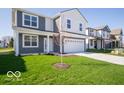 Two-story home with a two-car garage, green lawn and landscaping at 1573 Hanover St, Danville, IN 46122