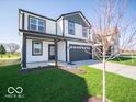 Well-manicured front yard and long driveway leading to the two-story home with white siding and black trim at 1579 Hanover St, Danville, IN 46122