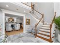 Elegant foyer with a staircase, marble tile flooring, and access to the living area at 2227 Hidden Orchard Ct, Indianapolis, IN 46228