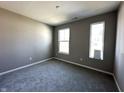 Neutral bedroom features plush carpeting, with ample natural light from two windows at 1023 Cyprian Way, Lebanon, IN 46052