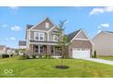Attractive two story home featuring brick accents, a covered porch, an attached garage, and manicured lawn at 15468 Streamwood Dr, Fishers, IN 46037