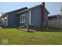 View of the home's exterior showing the fenced yard and landscaping at 1517 N E St, Elwood, IN 46036