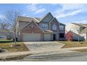 Traditional two-story home with brick facade, attached two-car garage, and spacious front lawn at 12997 Bartlett Dr, Fishers, IN 46037