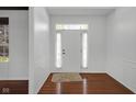 Bright foyer with hardwood floors, white walls, and a front door with glass inserts at 12997 Bartlett Dr, Fishers, IN 46037