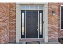 Elegant front door with sidelights and transom window, framed by brick and white trim at 12997 Bartlett Dr, Fishers, IN 46037