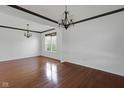 Spacious living room featuring hardwood floors, crown molding, and decorative chandeliers at 12997 Bartlett Dr, Fishers, IN 46037