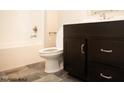Bathroom boasts dark brown vanity, a white toilet, and grey tile floor at 1684 Linden Ln, Greenfield, IN 46140