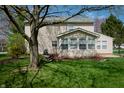 Expansive backyard featuring a well-maintained lawn and a sunroom addition to the rear of the home at 9563 England Ct, Noblesville, IN 46060