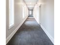 Hallway with gray carpet and white walls leading to the unit at 233 E Saint Joseph St # 3E, Indianapolis, IN 46202