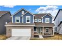 Charming two-story home with blue siding, brick accents, attached two-car garage, and a covered entryway at 7062 English Oak Dr, McCordsville, IN 46055