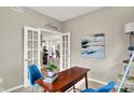 Bright office space featuring glass French doors, a modern desk, chairs, stylish shelving, and modern decor at 7062 English Oak Dr, McCordsville, IN 46055