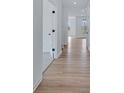 Bright hallway featuring hardwood floors, white walls, and a clear view of the layout at 16043 Meadow Frost Ct, Fishers, IN 46037