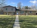 Exterior shot of a two-story home with a well-maintained lawn and walkway at 406 S Fenton Ave, Indianapolis, IN 46219