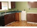 Kitchen with dark cabinets, green walls, and an undermount sink by the window at 406 S Fenton Ave, Indianapolis, IN 46219