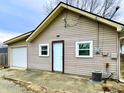 View of home's rear featuring a one car garage, neutral siding, and well-maintained exterior at 64 S 10Th Ave, Beech Grove, IN 46107