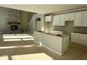 Spacious kitchen with white cabinets, large island, and stone fireplace at 6959 Oakdale Ln, Avon, IN 46123