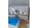 White kitchen cabinets, granite countertops, and a modern light fixture at 6959 Oakdale Ln, Avon, IN 46123