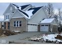 Two-story home with gray siding, brick accents, and a three-car garage at 6973 Oakdale Ln, Avon, IN 46123