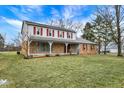 Classic two-story home with a brick facade, covered porch, and spacious front yard at 7330 Tousley Dr, Indianapolis, IN 46256