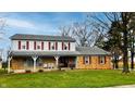 Traditional two-story home with a brick and siding exterior, complemented by a green lawn and mature trees at 7330 Tousley Dr, Indianapolis, IN 46256