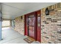 Close-up of an inviting front entrance featuring a storm door, brick accents, and a welcome mat at 7330 Tousley Dr, Indianapolis, IN 46256
